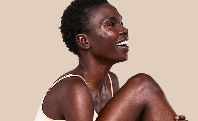 smiling woman with radiant skin on body and face from aveeno